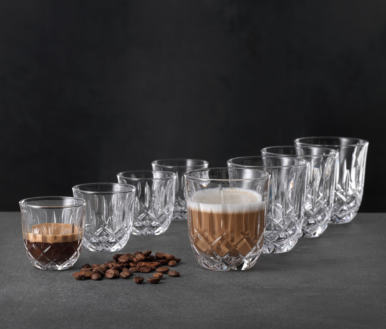 Abbildung von sechs Nachtmann Cappuccinogläsern »Noblesse«, von denen zwei mit Kaffee gefüllt sind, zusammen mit Kaffeebohnen.