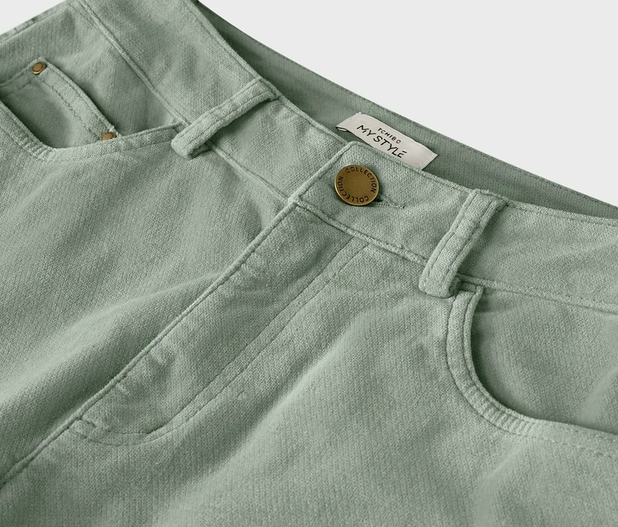 Detailaufnahme einer hellgrünen Cordhose mit Knopf und Gürtelschlaufen.