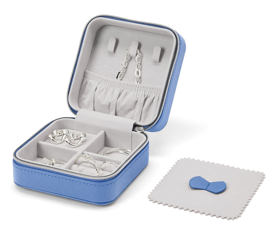 Offene blaue Schmuckschatulle mit silbernen Schmuckstücken und einem Poliertuch.
