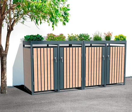 Eine Mülltonnenbox mit Blumenkasten für 4 Mülltonnen steht neben einem Baum.