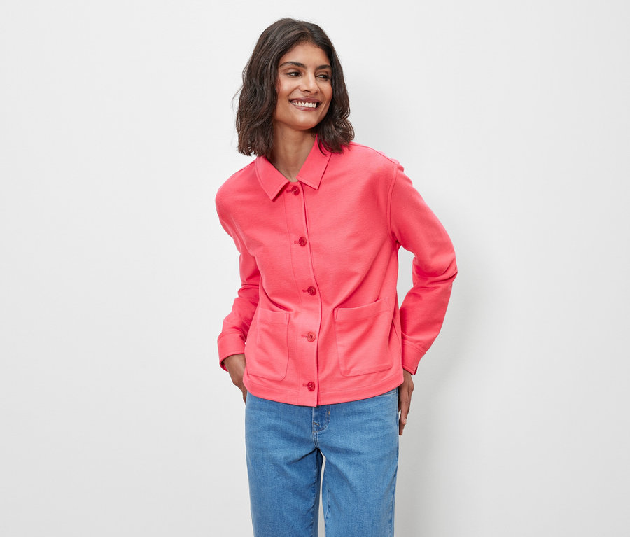 Frau posiert in Jerseyjacke in Pink.