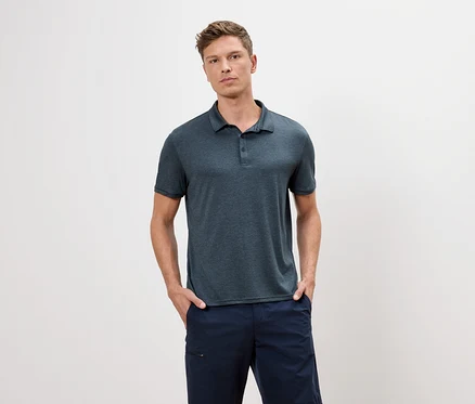 Mann mit blauem Poloshirt und blauen Shorts steht vor einem weißen Hintergrund.