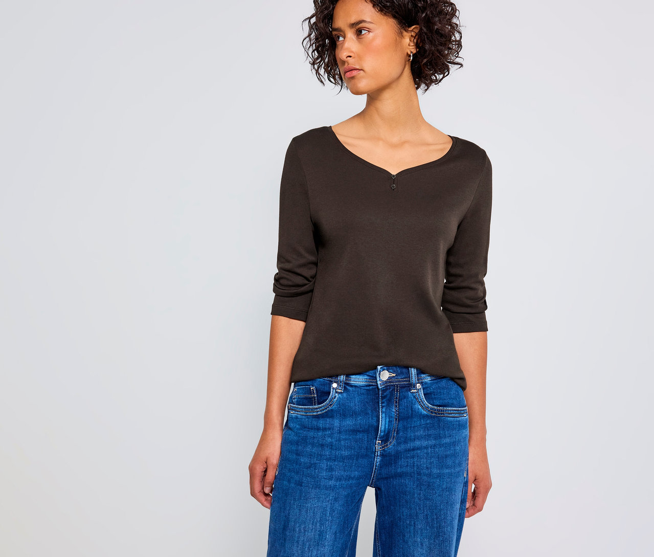 Frau trägt ein braunes Street One 3/4-Shirt mit Knopfdetail und blaue Jeans.