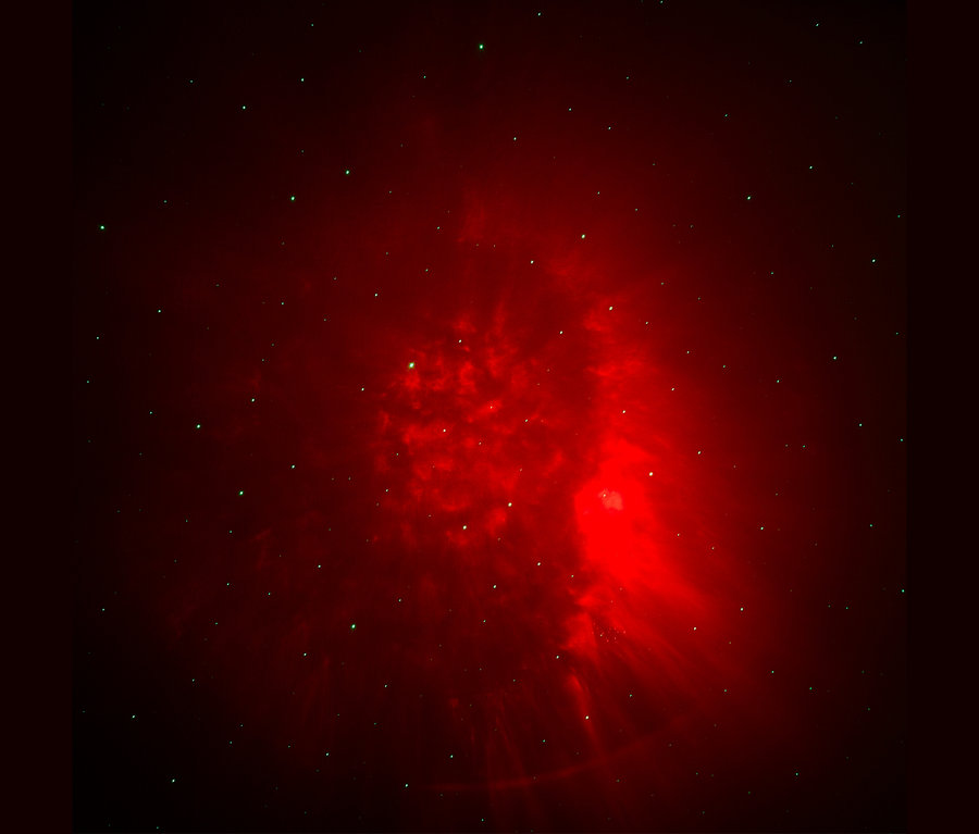 Ein roter Nebel mit Sternen auf dunklem Hintergrund.