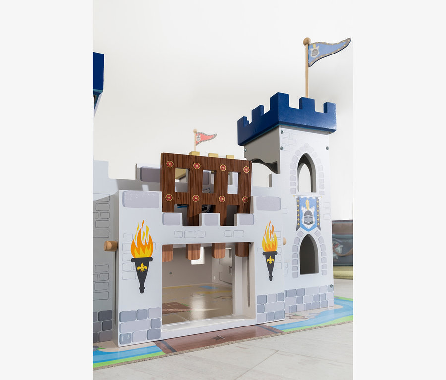 Ein weiß-graues Holzspielzeugschloss mit blauen Türmen, einem hochgezogenen braunen Fallgatter und gemalten Fackeln.