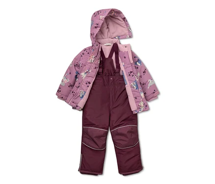 Lila Kinderjacke mit Katzenmuster und offener Kapuze über einer weinroten Latzhose.