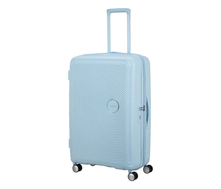 Großer American Tourister Soundbox Hartschalen-Koffer in Pastellblau mit ausgefahrenem Griff, vier Rollen und konzentrischen Kreismustern.