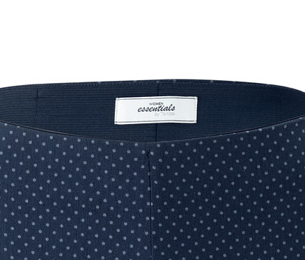 Detailaufnahme einer Stretchhose in 3/4-Länge mit dunkelblauem Hintergrund und hellgrauem Punktmuster.
