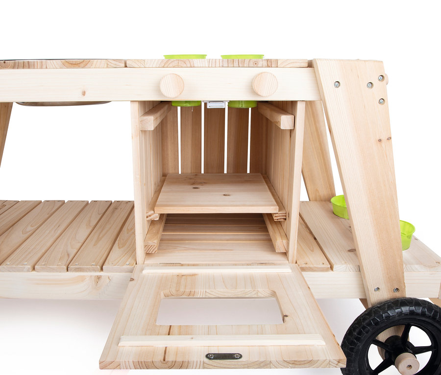 Detailansicht der small foot Matschküche aus Naturholz mit offenem Schrank und grünem Zubehör.