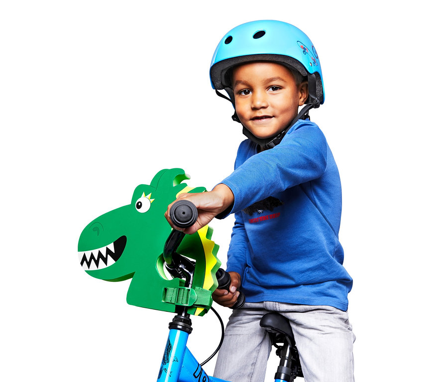 Junge mit blauem Helm auf einem Fahrrad mit Kinder-Lenkeraufsatz »Drache«.