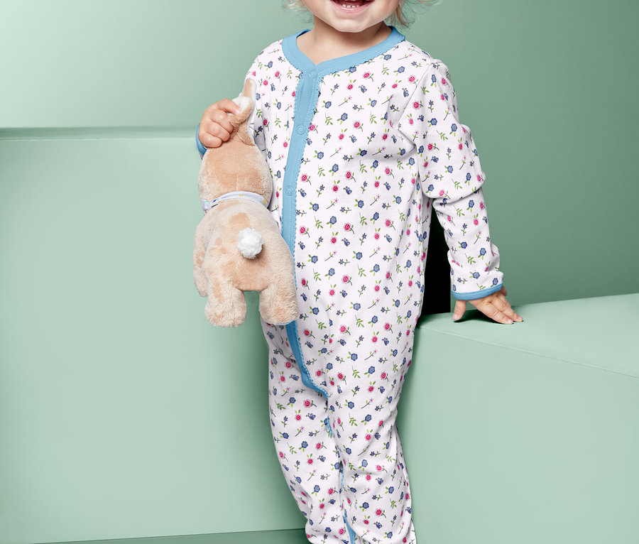 Ein Kind im Schlafanzug hält einen Stoffhasen.