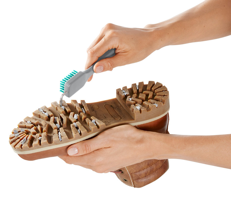 Hände reinigen eine Schuhsohle mit einem Grobschmutz-Schuhsohlenreiniger.