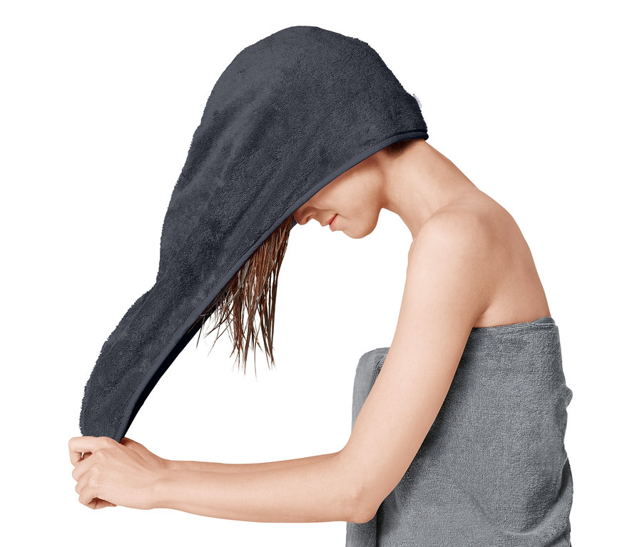 Frau legt ein Turban-Handtuch um ihre nassen Haare.