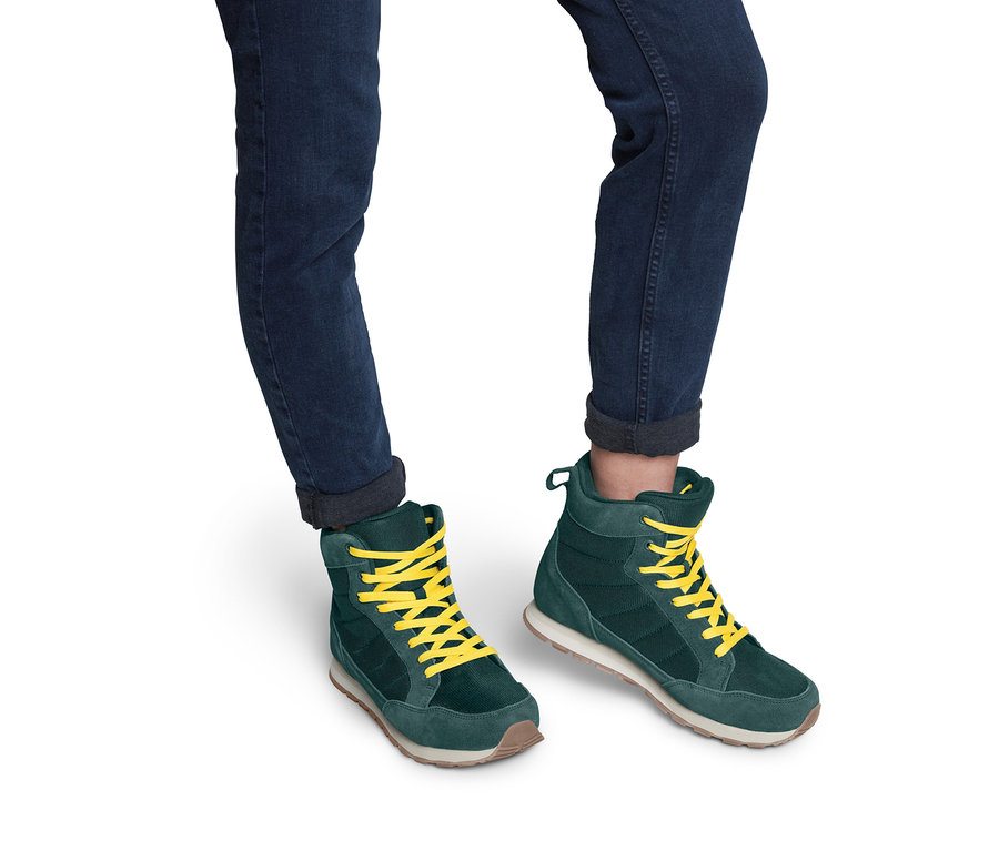 Beine in Jeans und Trekkingschuhen.