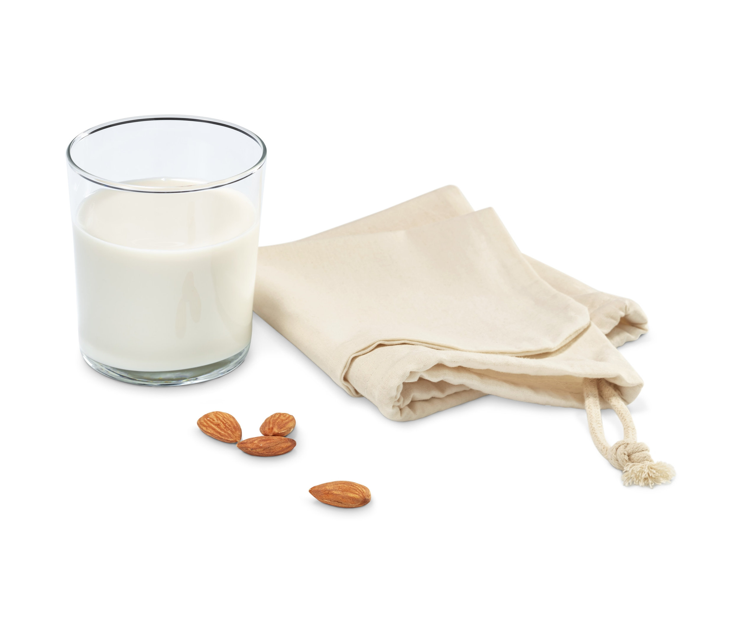 Ein Glas Milch steht neben zwei Nussmilchbeuteln und einigen Mandeln.