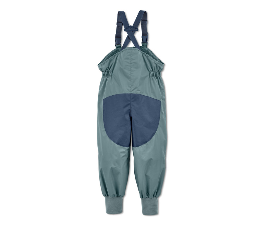 Eine grüne Regenhose aus recyceltem Material mit Mitwachsfunktion auf weißem Hintergrund.