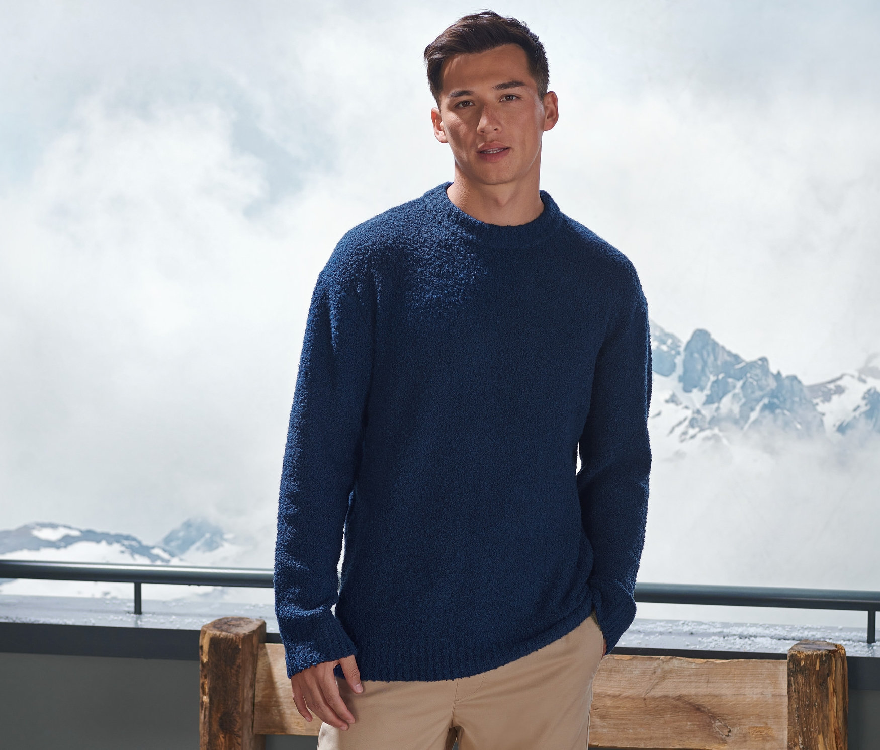 Mann trägt einen Strickpullover.