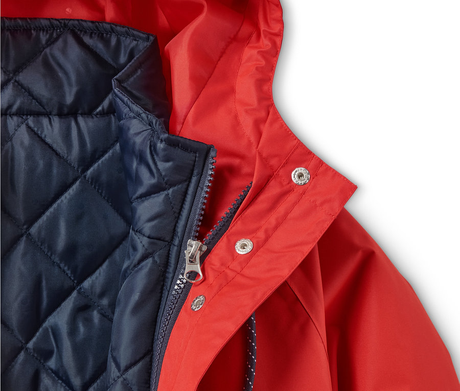 Detailansicht einer roten 3-in-1-Regenjacke mit dunkelblauer Innenweste.