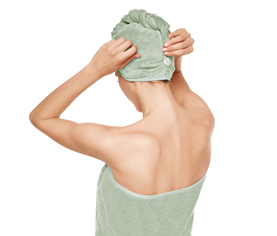 Frau befestigt ein grünes Turban-Handtuch.