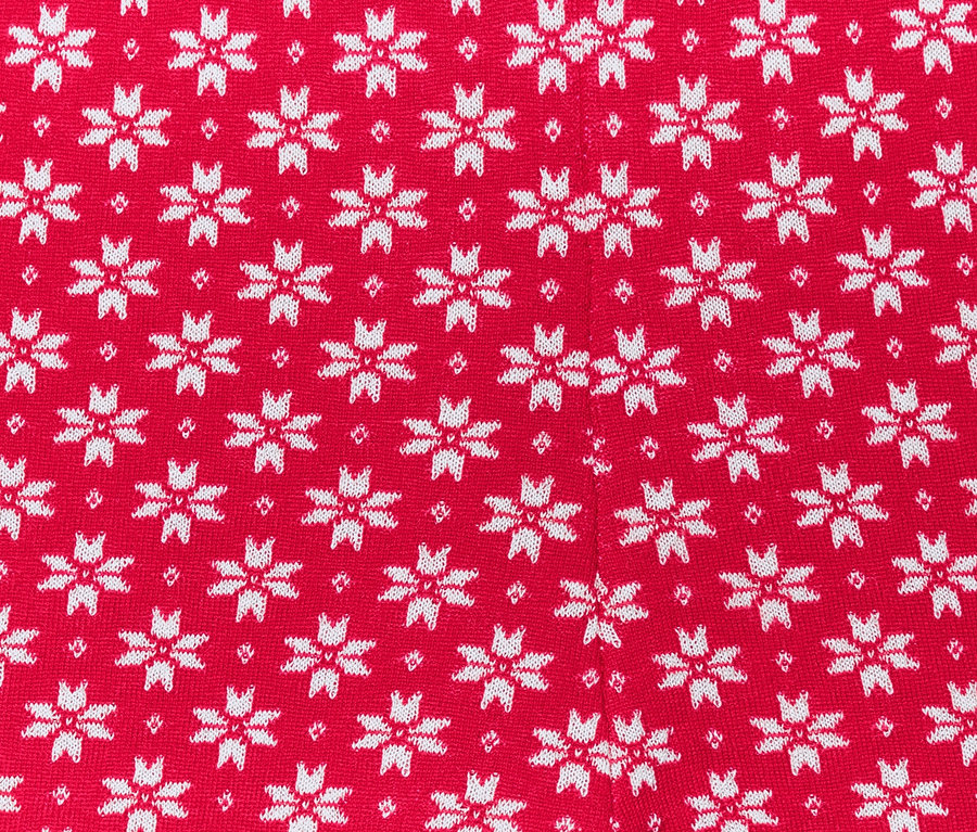 Detailaufnahme von roten Strickleggings mit weißen Schneeflocken.