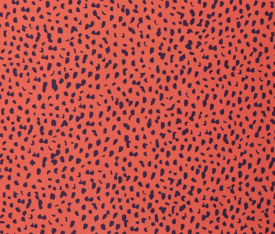 Nahaufnahme eines gemusterten Stoffs mit orangefarbenem Hintergrund und dunkelblauen Flecken. Blusenkleid aus Viskose.