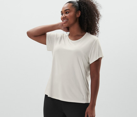 Frau posiert in Sporttight, schwarz und Funktionsshirt, offwhite.