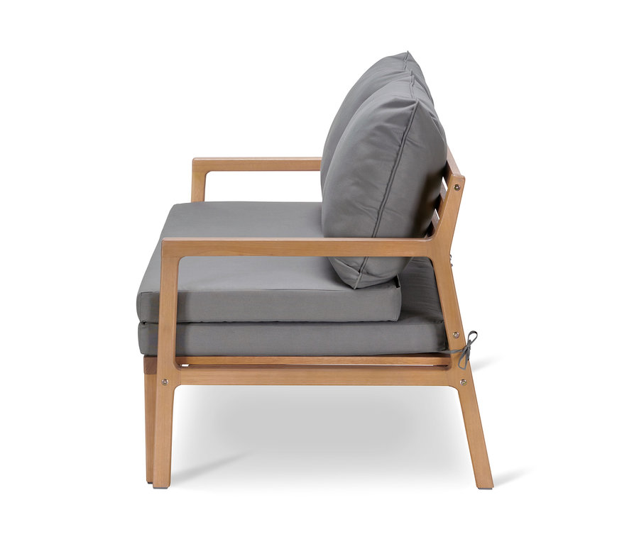 Seitenansicht eines Loungesofas mit ausziehbarem Fußteil, Eukalyptusholzrahmen und grauen Kissen.