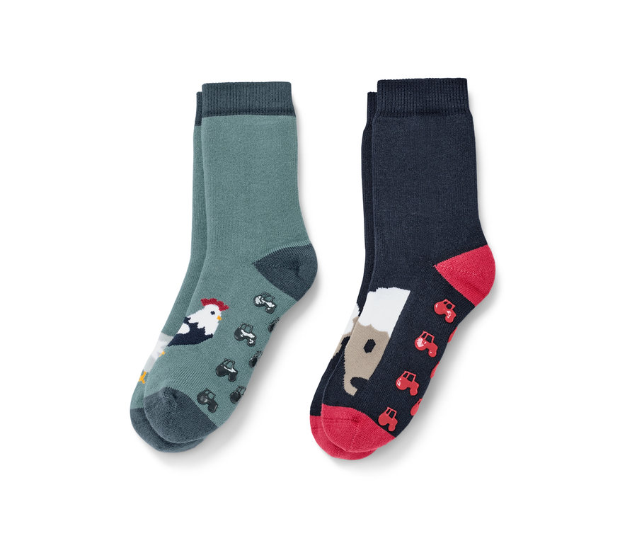 Zwei Paar Kleinkind-Antirutsch-Socken, Farm Motiv. Ein Paar grün mit Hahn und Traktoren, das andere dunkelblau mit Pferd und Traktoren.