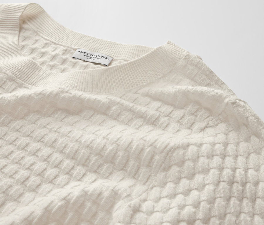 Detailansicht eines strukturierten Strickpullovers.