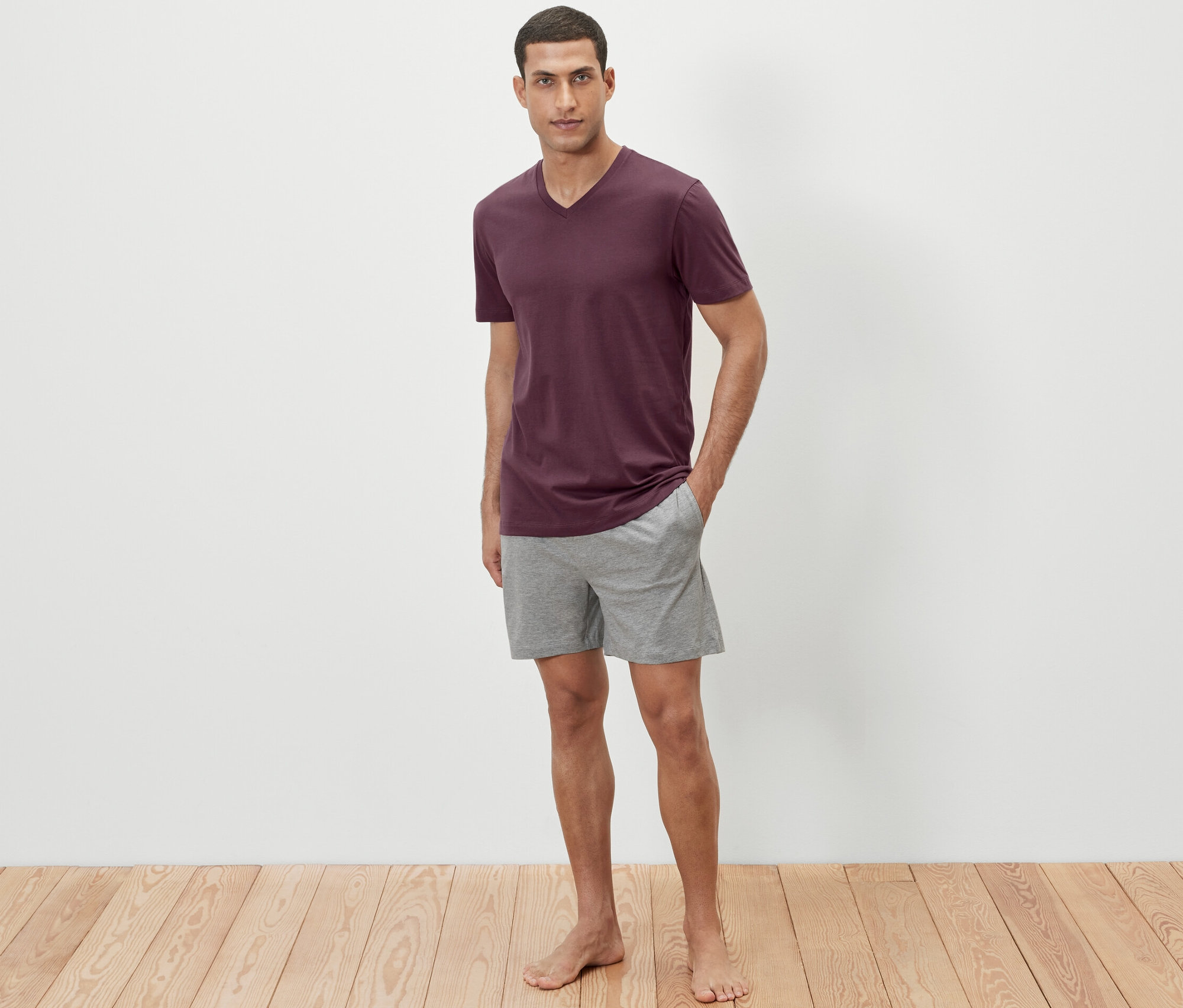 Mann steht in Shorty-Pyjama.