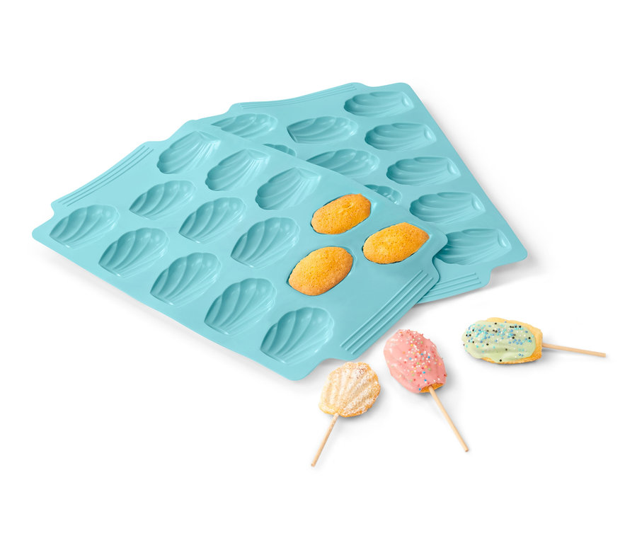 Zwei hellblaue 2 Madeleine-Backformen, mit gebackenen Madeleines und Madeleines am Stiel.