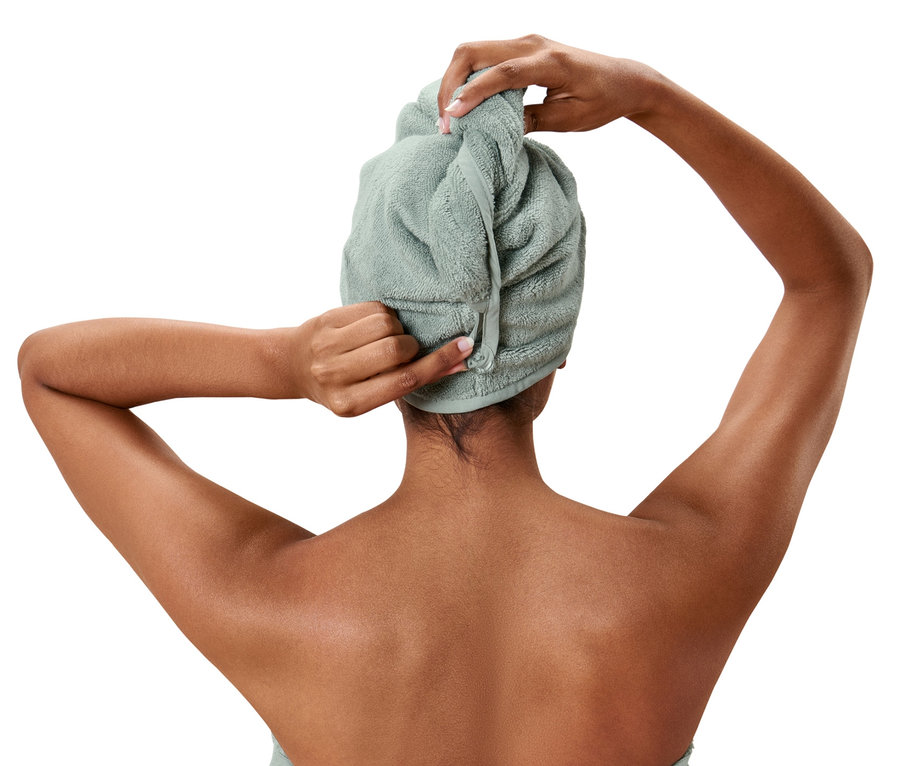 Frau bindet ein Turban-Handtuch um ihr Haar.