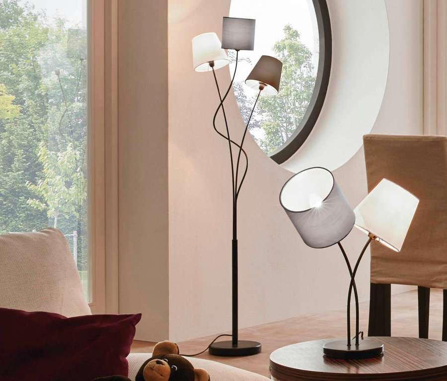 Wohnzimmer mit braunem Teddybär auf beigem Kissen auf Sofa, im Hintergrund Fenster und Eglo-Stehleuchte »Maronda«.