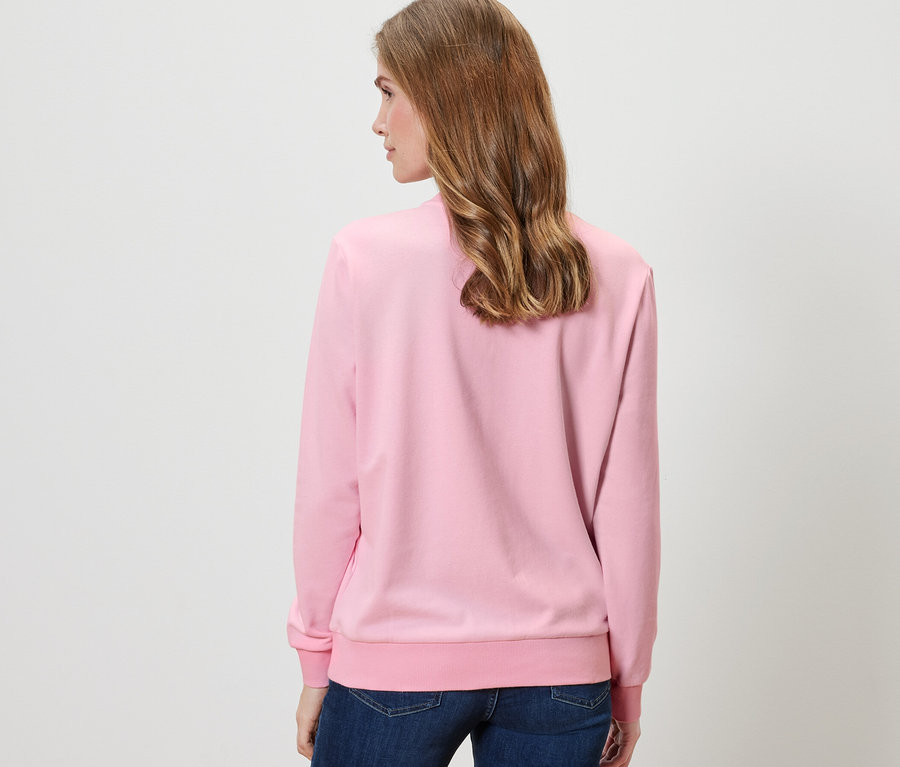 Frau von hinten trägt rosa Sweatshirt.