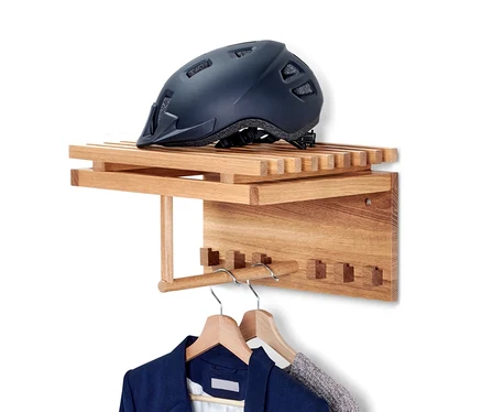 Eine hängende Wandgarderobe mit blauem Sakko und grauem Pullover hängt. Ein dunkelblauer Helm liegt auf dem oberen Regal.
