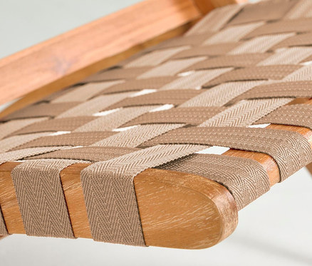 Detailansicht eines zusammenklappbaren Loungesessels mit Holzrahmen und beigefarbenem Textilgeflecht.