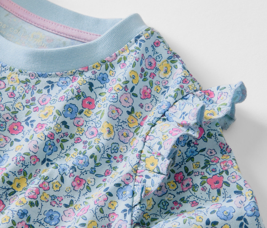 Detailansicht eines Kinder-Langarmshirts mit Blumenmuster.