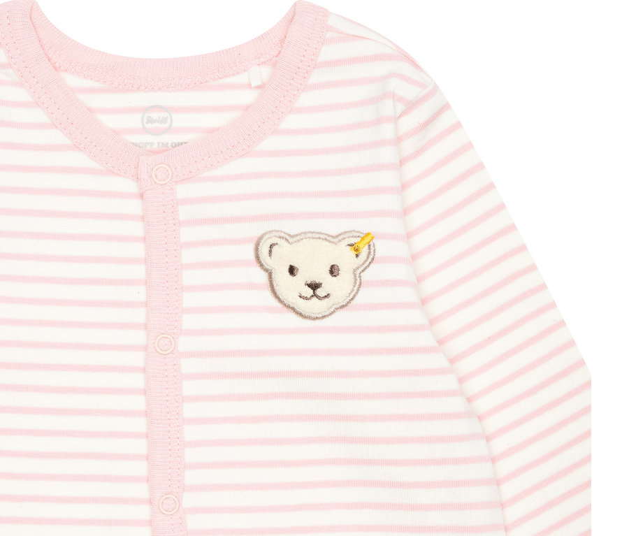Detail eines rosa-weiß gestreiften Steiff Baby-Stramplers mit Knopfleiste und Bärenapplikation.