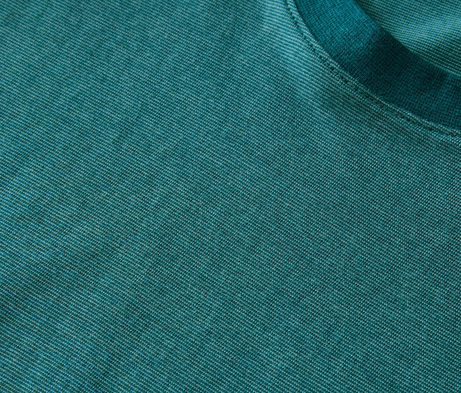 Detailaufnahme eines türkisfarbenen Shorty-Pyjama-Sets mit melierter Jersey-Textur und Rundhalsausschnitt.