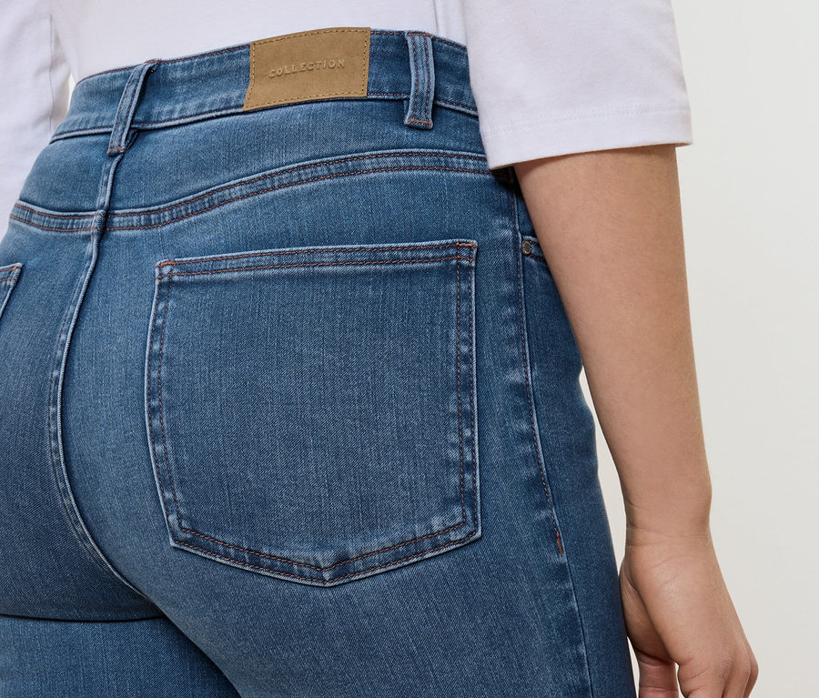 Detailansicht der Rückseite von blauen Jeans mit braunem Etikett mit der Aufschrift COLLECTION.