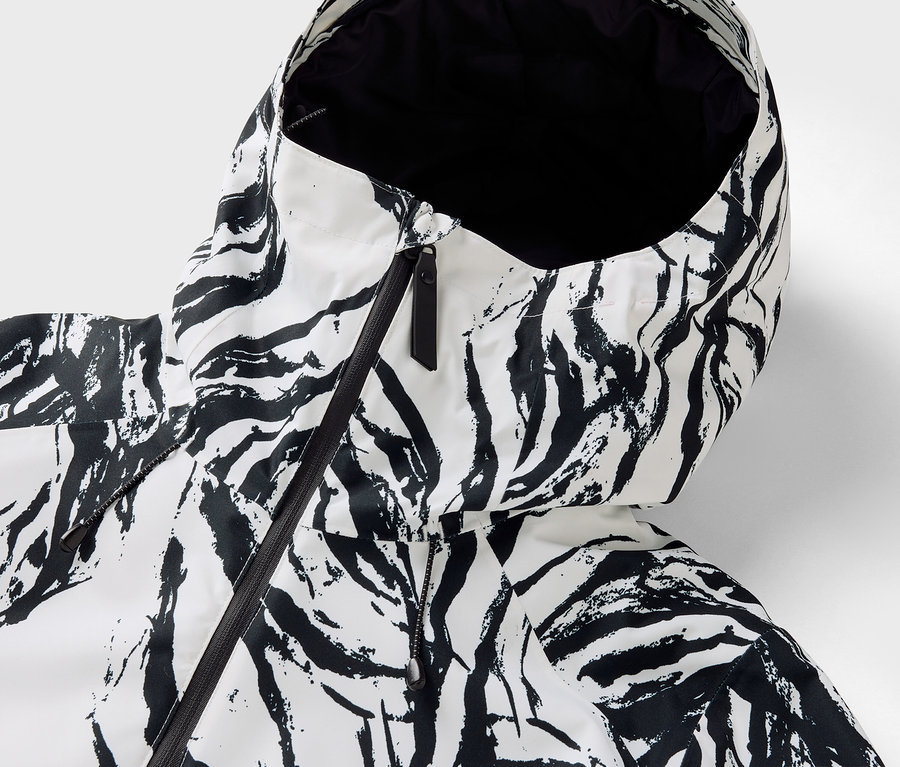Detailansicht der Kapuze einer Jacke mit Zebra-Muster und schwarzem Reißverschluss.