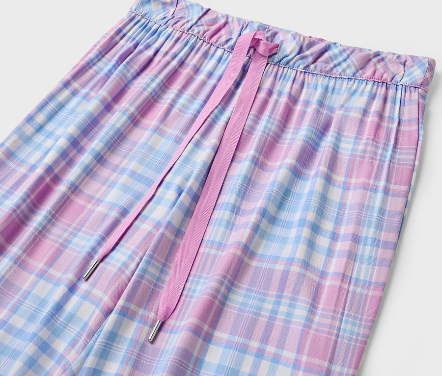 Detailaufnahme einer karierten Damenhose mit pinkfarbenem Kordelzug.