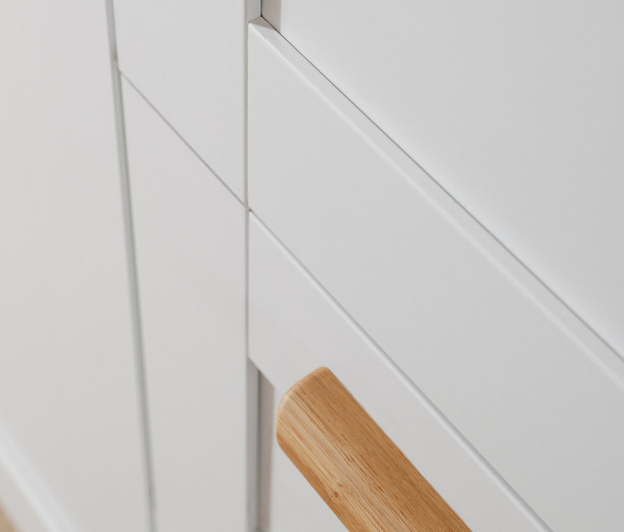 Detailaufnahme eines weißen rauch Drehtürenschranks »Quadra-Spin Country« mit Holzgriff.