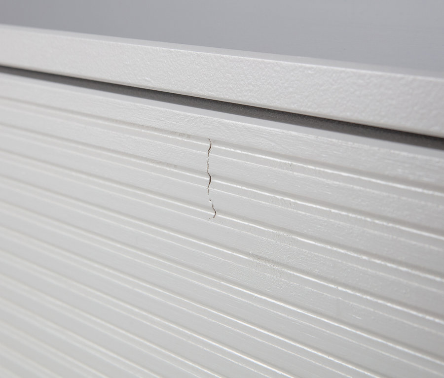 Detailansicht eines wolkengrauen Woood Garderobenschranks »Madu« mit einem Riss.