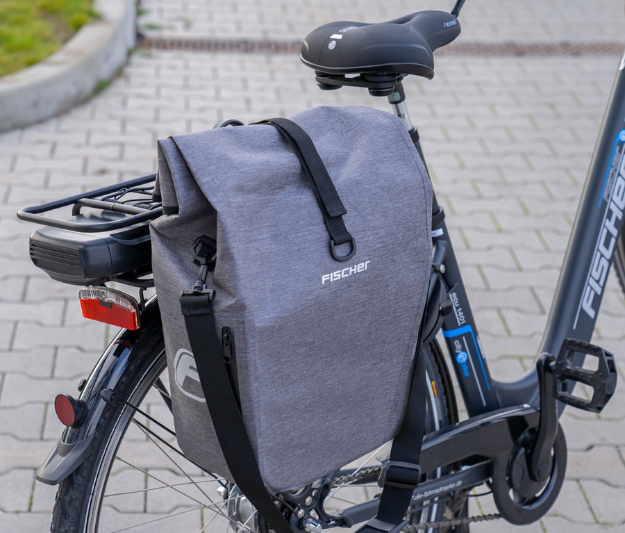 Eine graue Fischer Gepäckträgertasche PLUS Cita ist an einem Fahrrad befestigt.