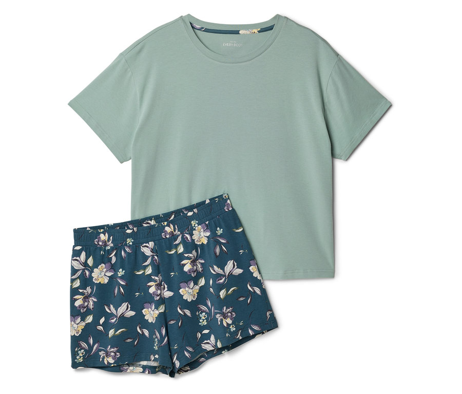 Ein hellgrünes T-Shirt liegt neben einer dunkelblauen, kurzärmeligen Shorts mit Blumenmuster.