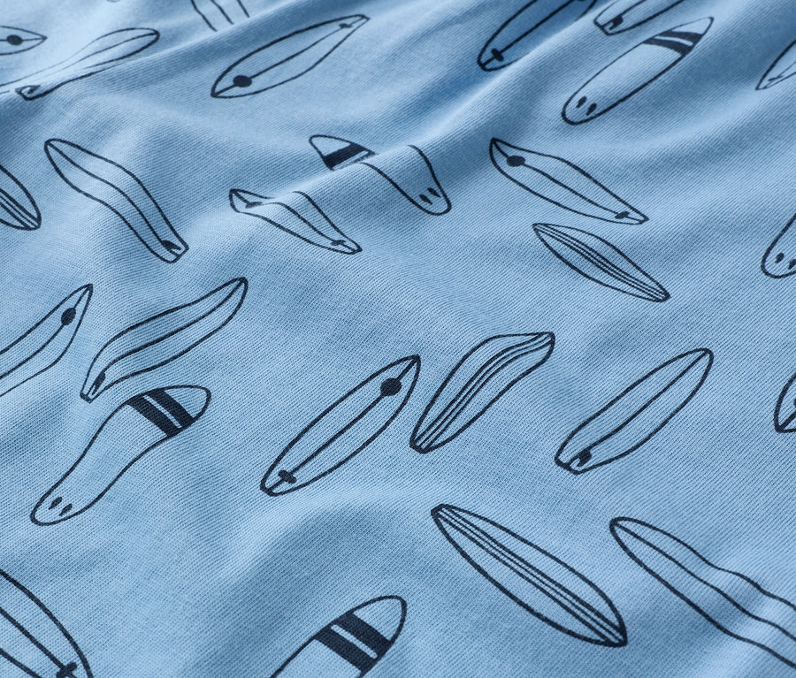 Nahaufnahme eines hellblauen Stoffes mit schwarzem Surfbrettmuster.