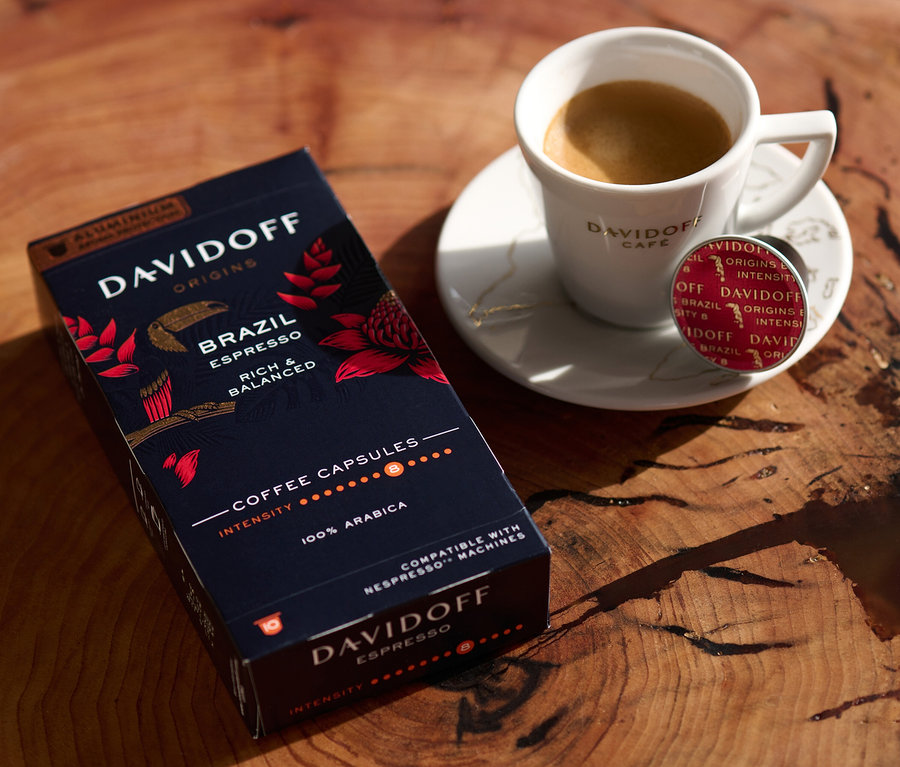Auf einem Holztisch stehen eine Packung DAVIDOFF CAFÉ ORIGINS Brazil Espresso, eine Tasse Espresso und eine Kapsel.
