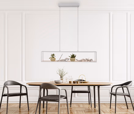Ein modernes Esszimmer mit einem ovalen Holztisch und vier dunklen Stühlen. Über dem Tisch hängt eine rechteckige Pendelleuchte mit zwei kleinen Topfpflanzen und Treibholz. Der Raum hat weiße getäfelte Wände und einen Parkettboden.