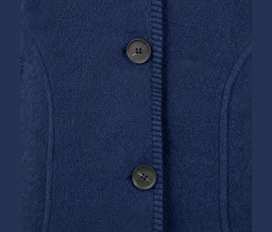 Blauer Wollmantel mit zwei dunklen Knöpfen an einer gerippten Knopfleiste.